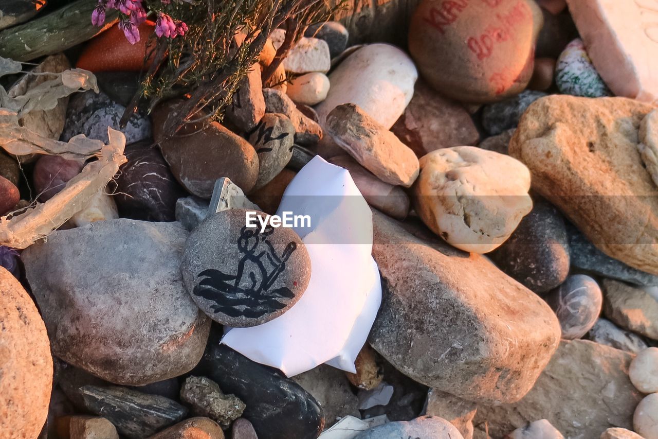 HIGH ANGLE VIEW OF PEBBLES ON ROCKS