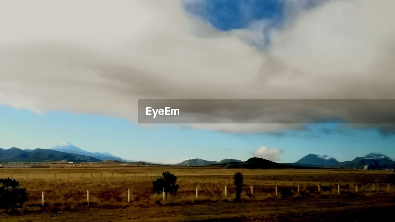 REAR VIEW OF TWO PEOPLE WALKING ON LANDSCAPE