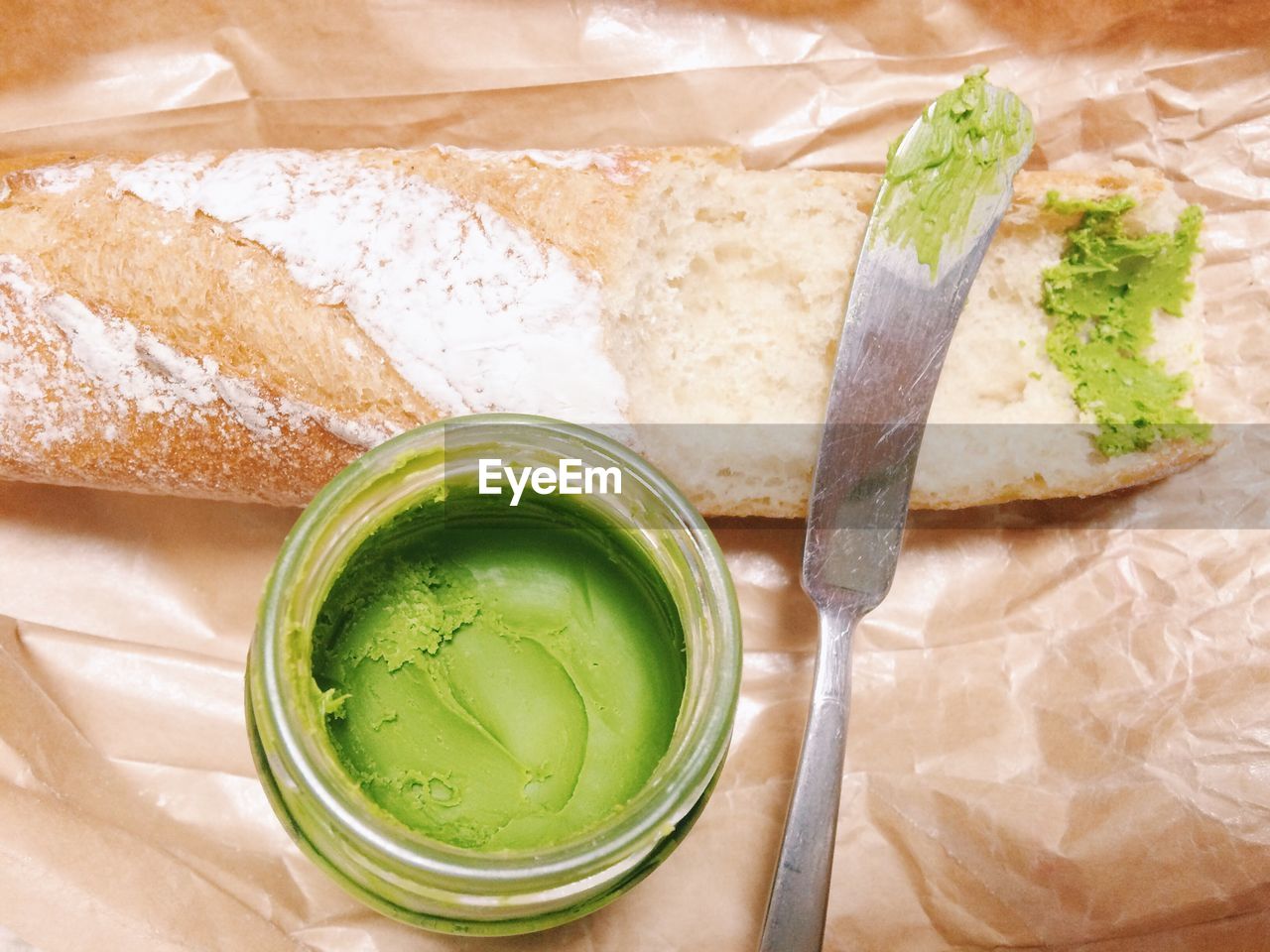 Directly above shot of green sauce with bread and table knife