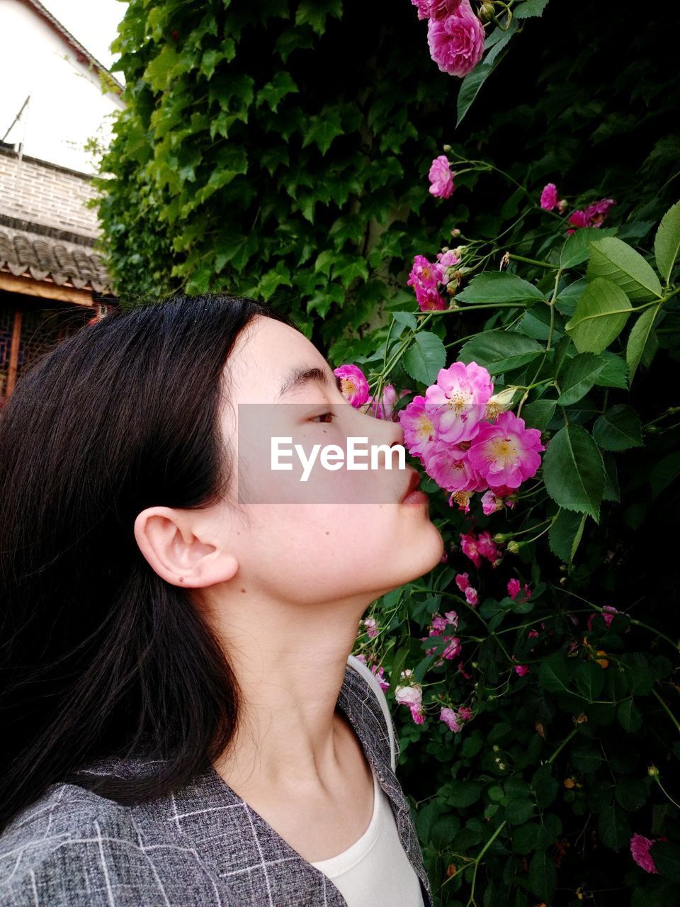 Young woman smelling pink flowers