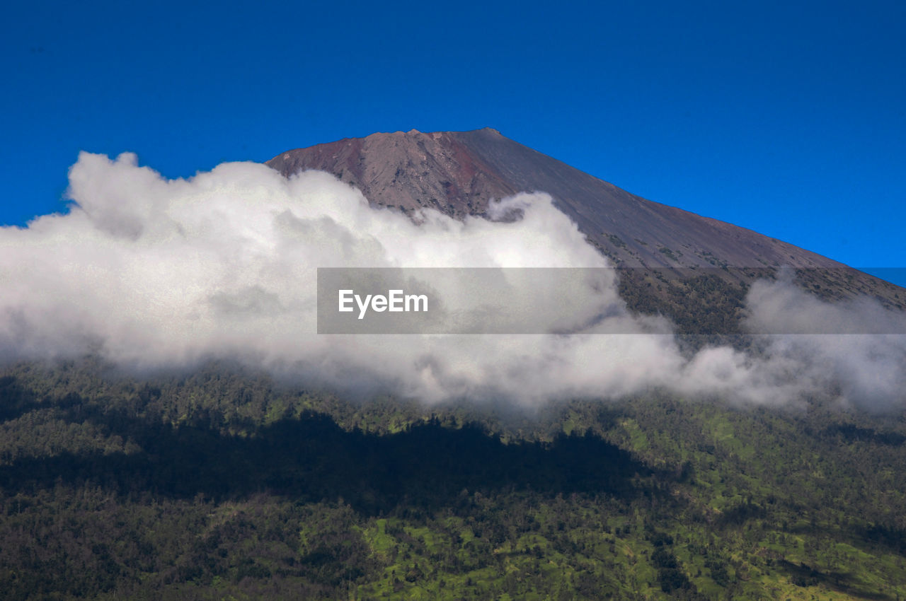 Low angle view of mountains against clear blue sky