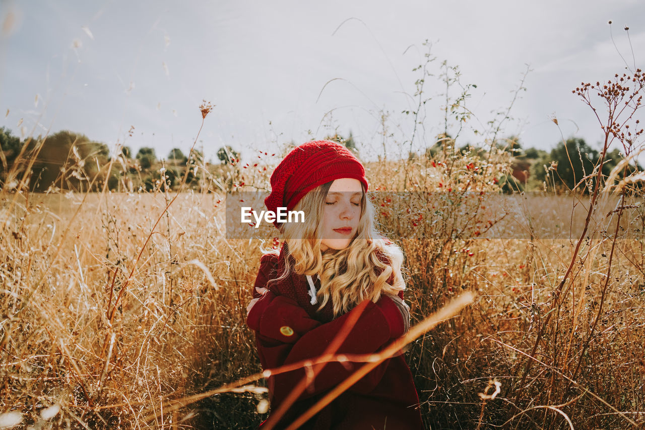 Beautiful woman with eyes closed sitting amidst plants