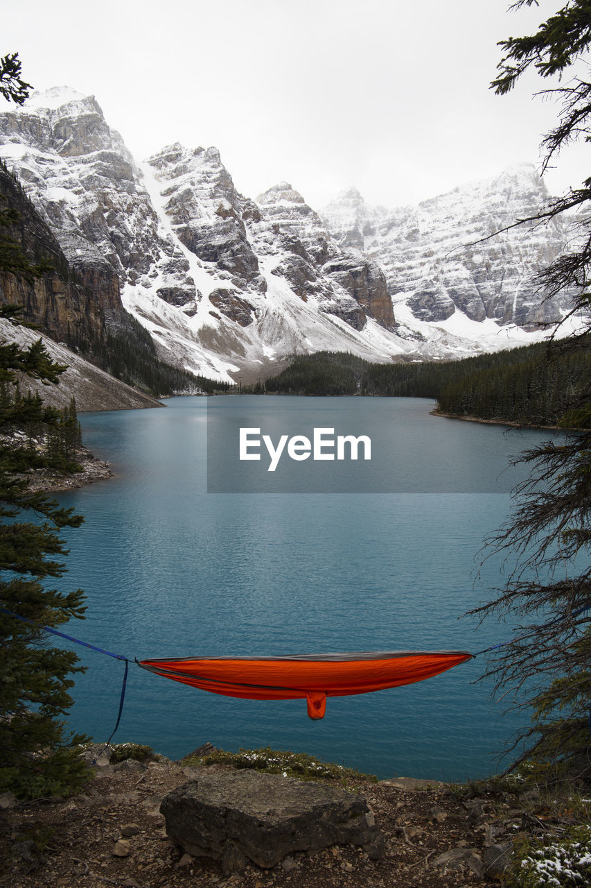 Scenic view of lake by mountains against sky