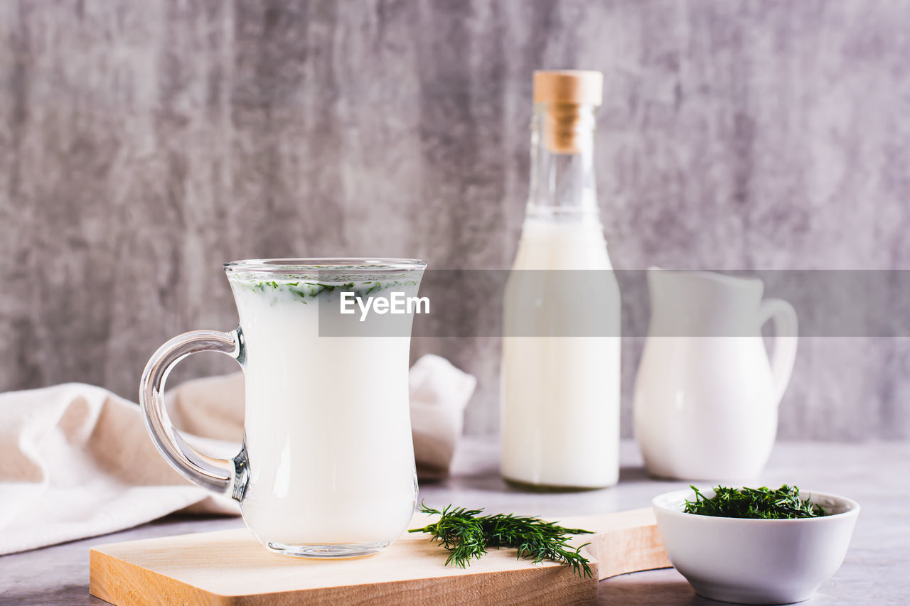 Ayran homemade yogurt drink with dill in a glass on the table