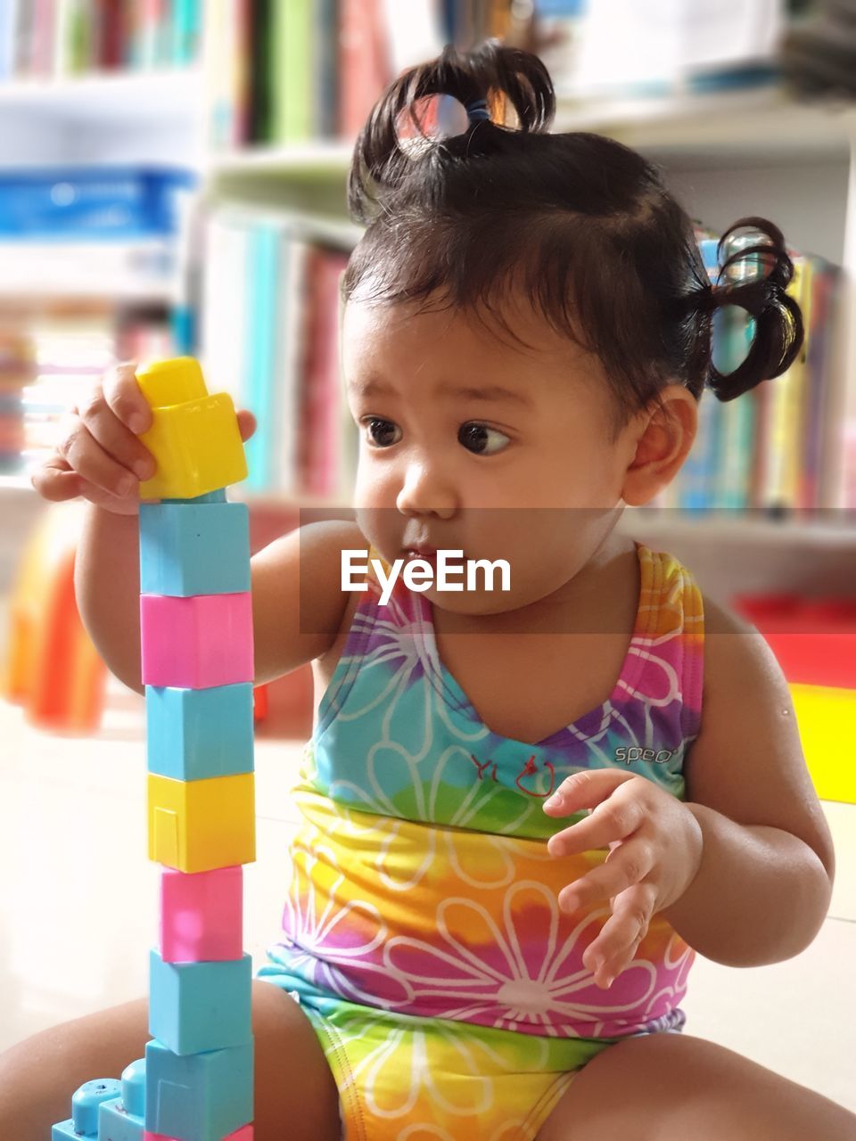 Cute baby girl playing with toy blocks