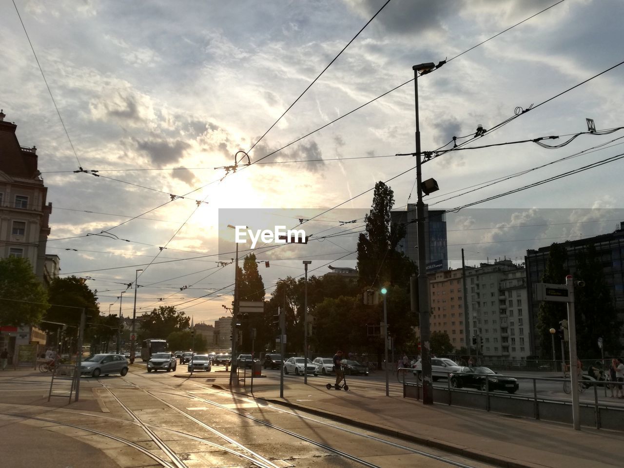 City street and buildings against sky during sunset