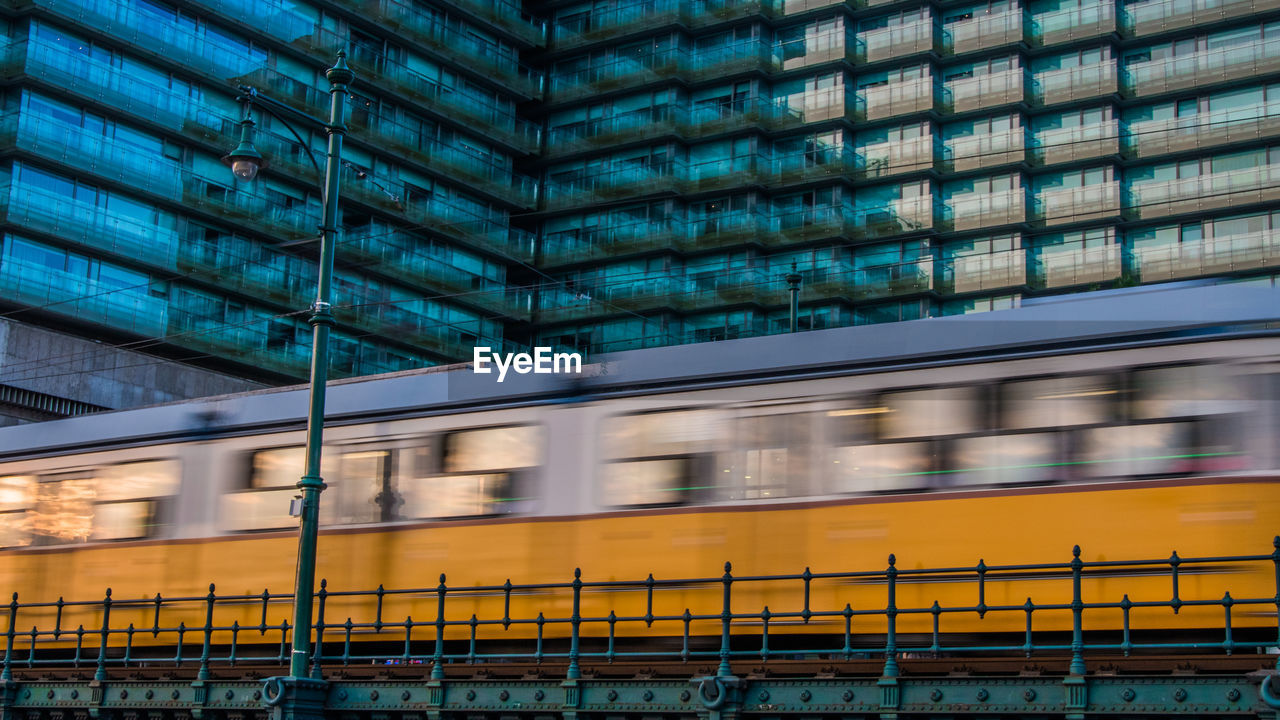 Blurred motion of train against building in city 