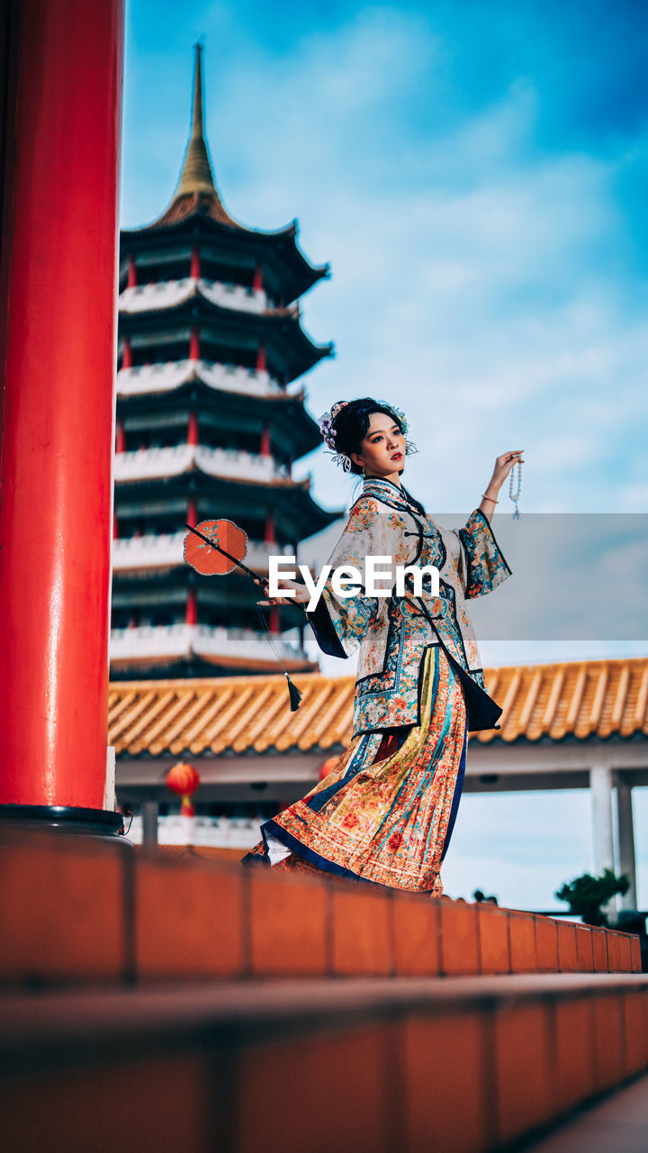 architecture, one person, adult, sky, clothing, built structure, religion, temple - building, nature, travel destinations, history, building exterior, building, tradition, the past, belief, cloud, traditional clothing, arts culture and entertainment, men, outdoors, spirituality, full length, place of worship, travel, standing