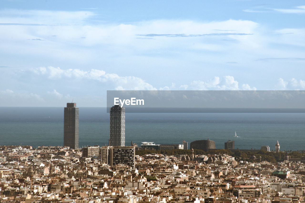 Scenic view of sea by buildings against sky