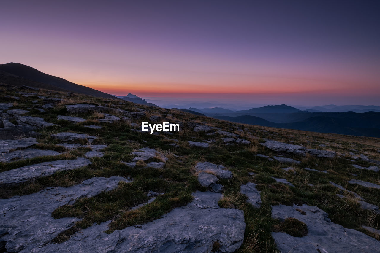 Scenic view of mountains against sky at sunset