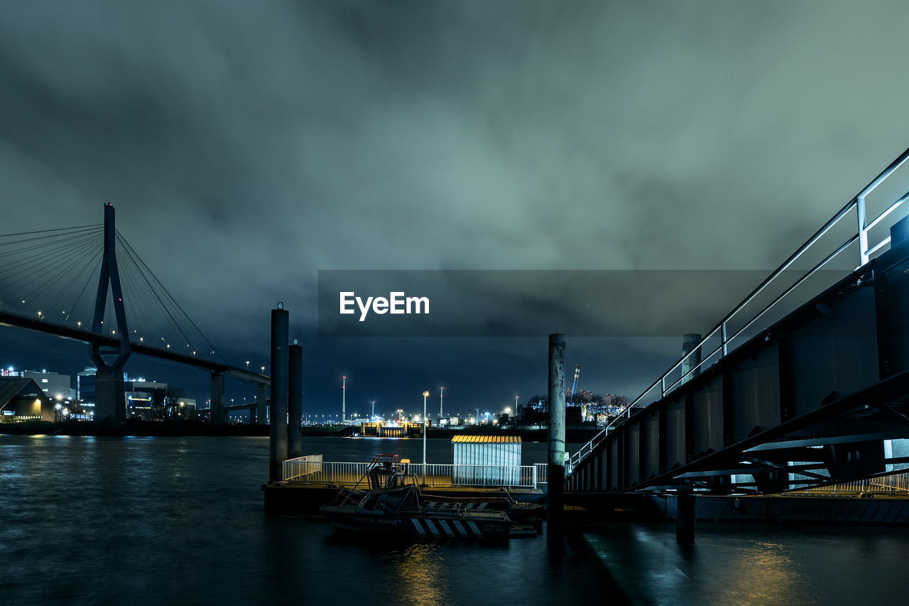 Bridge over river against cloudy sky