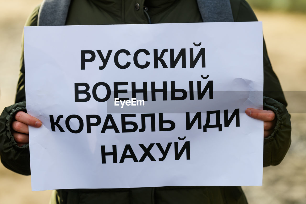 Midsection of woman holding banner