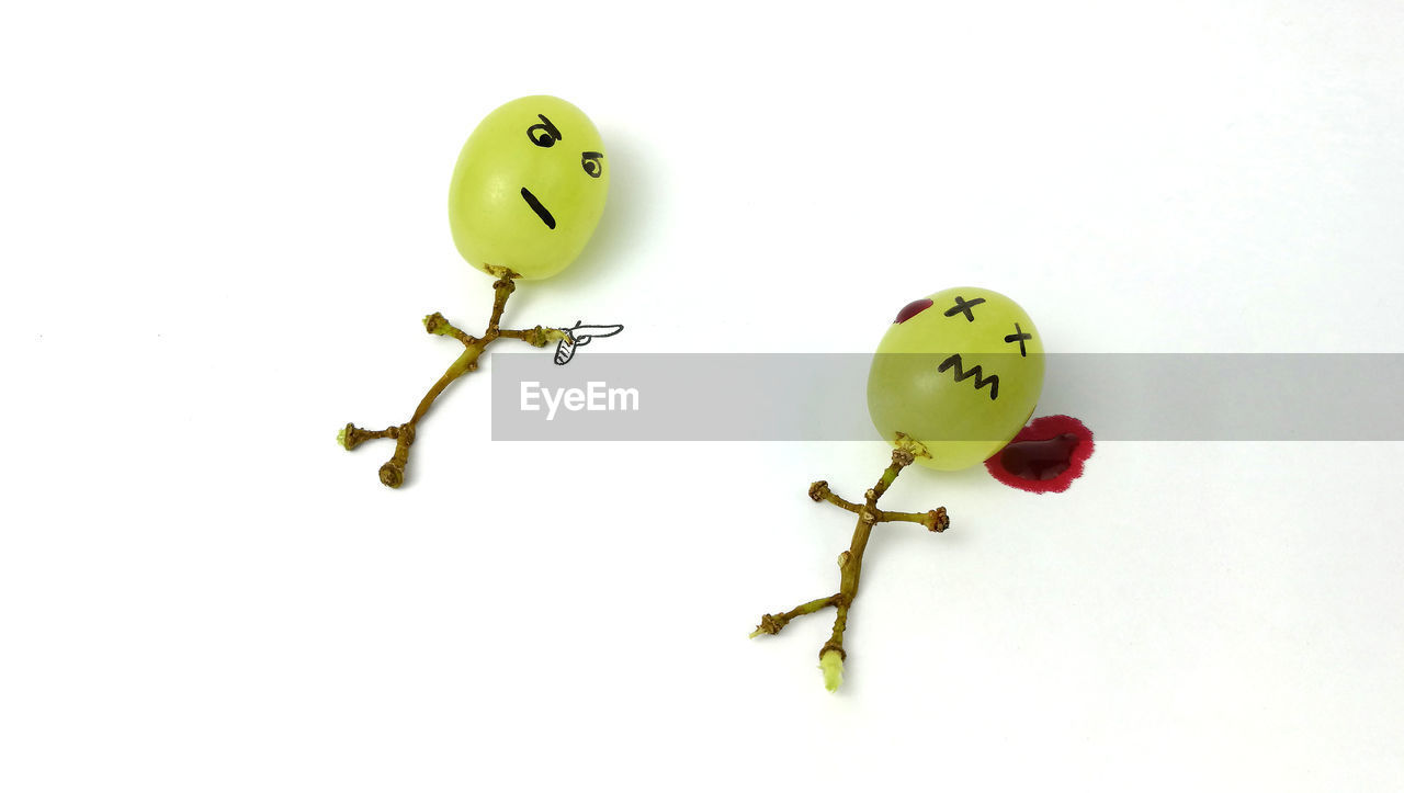 Grapes with anthropomorphic face on white background