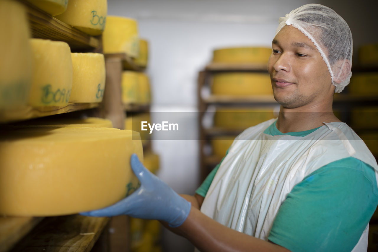 Cheese factory worker controlling maturation of cheese