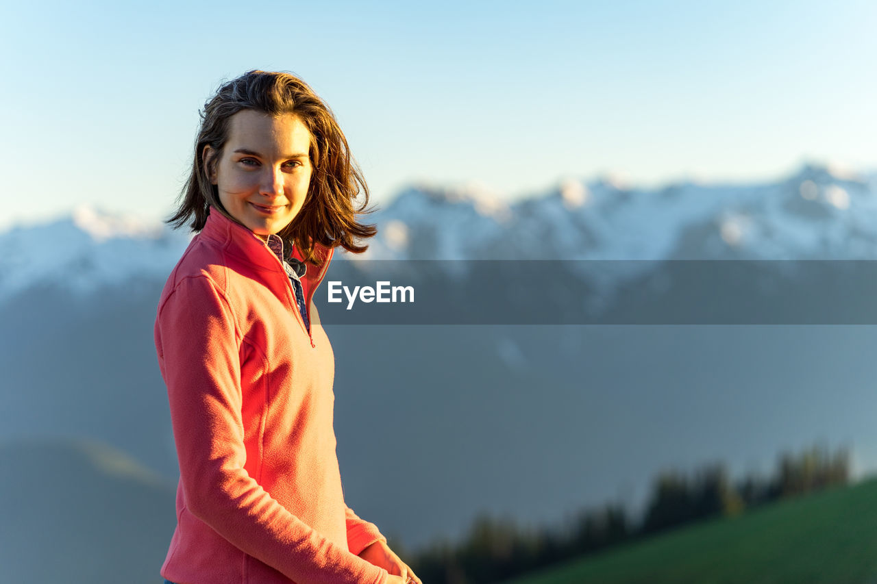 Woman hiker in pink fleece at sunset over olympic national park