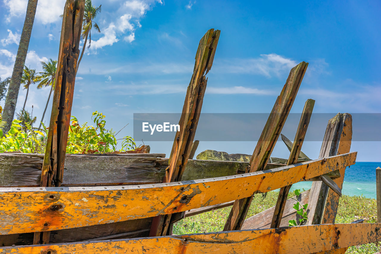 RUSTY METALLIC STRUCTURE ON SHORE AGAINST SKY