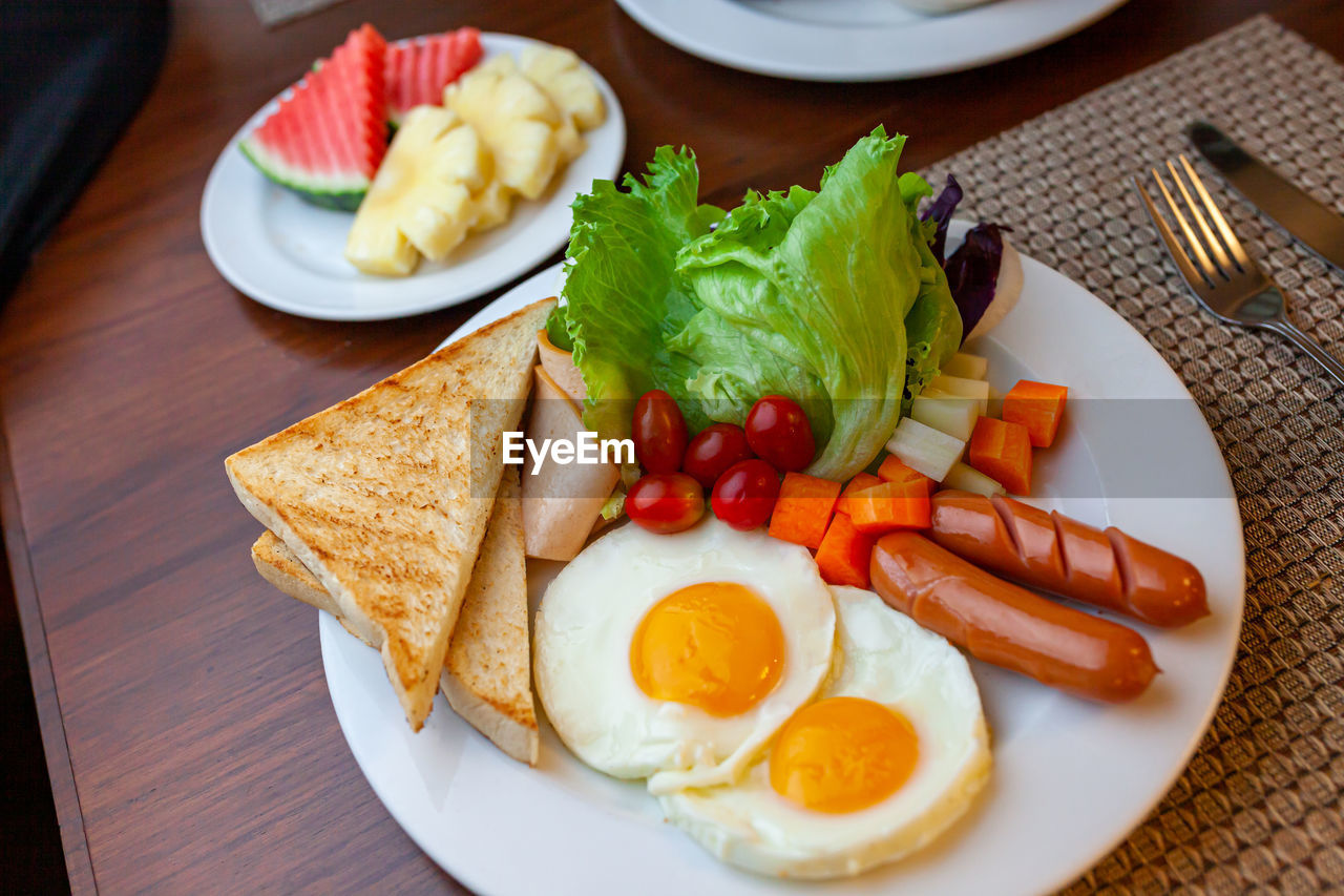 Full american breakfast. sunny side fried eggs, roasted bacon, hash brown and toasts