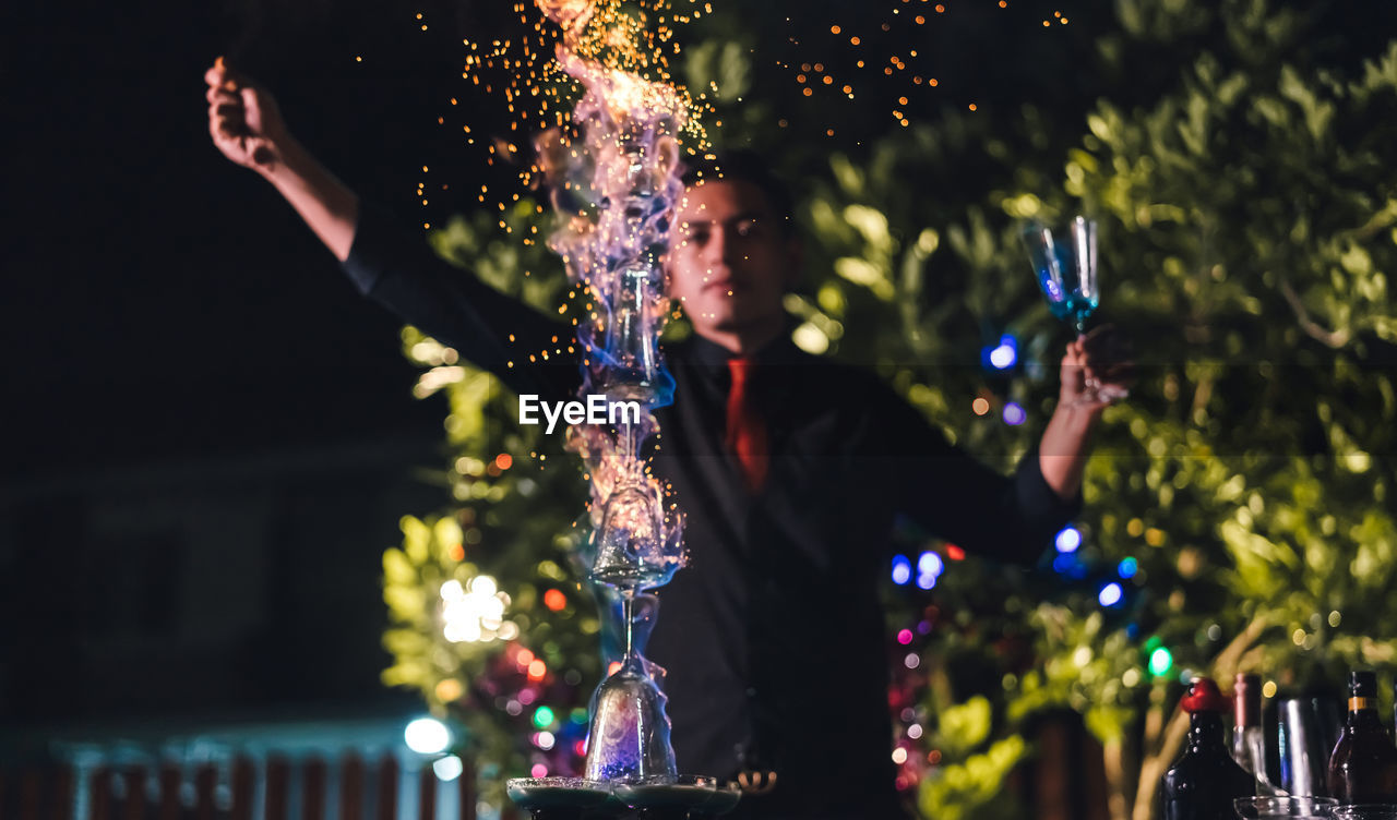 Young bartender working in party at night