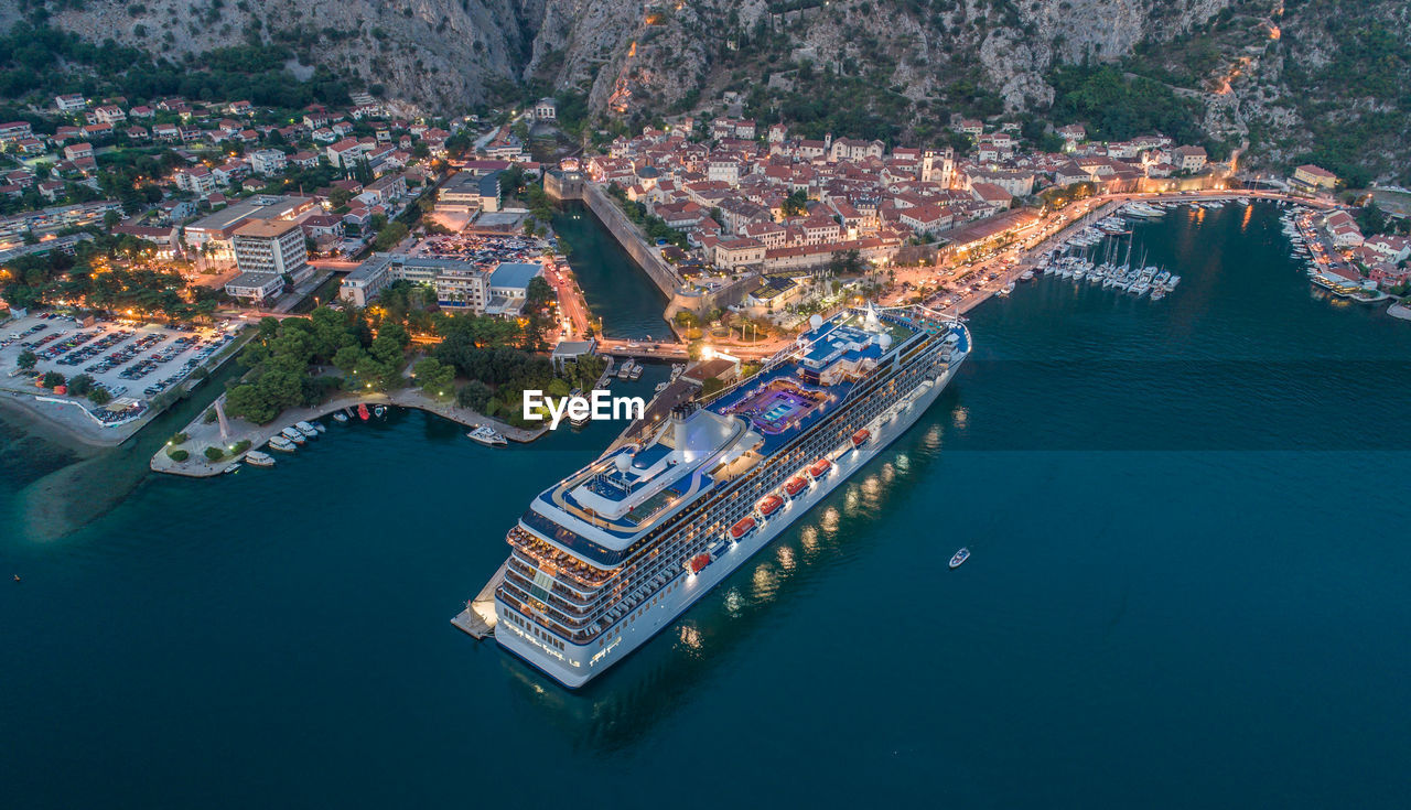 High angle view of cruise ship by cityscape