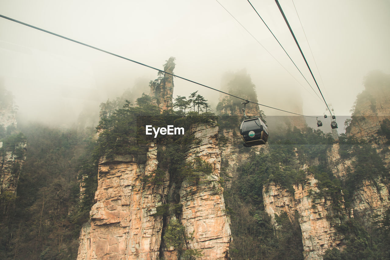 VIEW OF OVERHEAD CABLE CARS AGAINST SKY