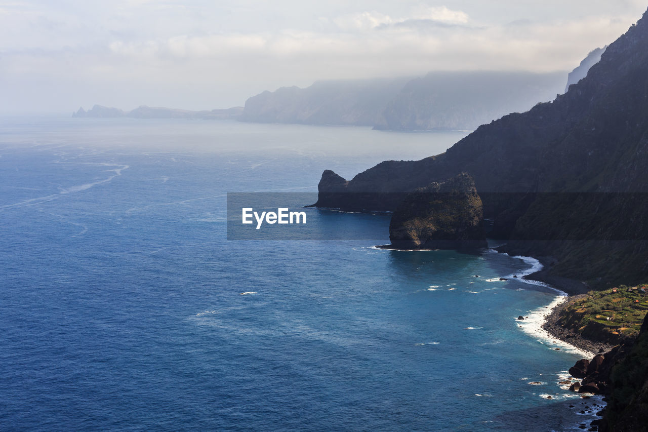 SCENIC VIEW OF SEA BY MOUNTAINS AGAINST SKY