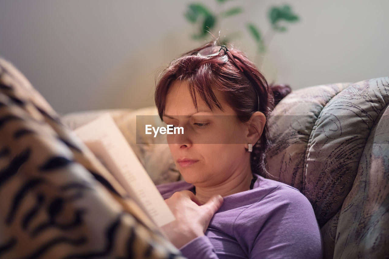 GIRL LOOKING AWAY WHILE RELAXING ON BED