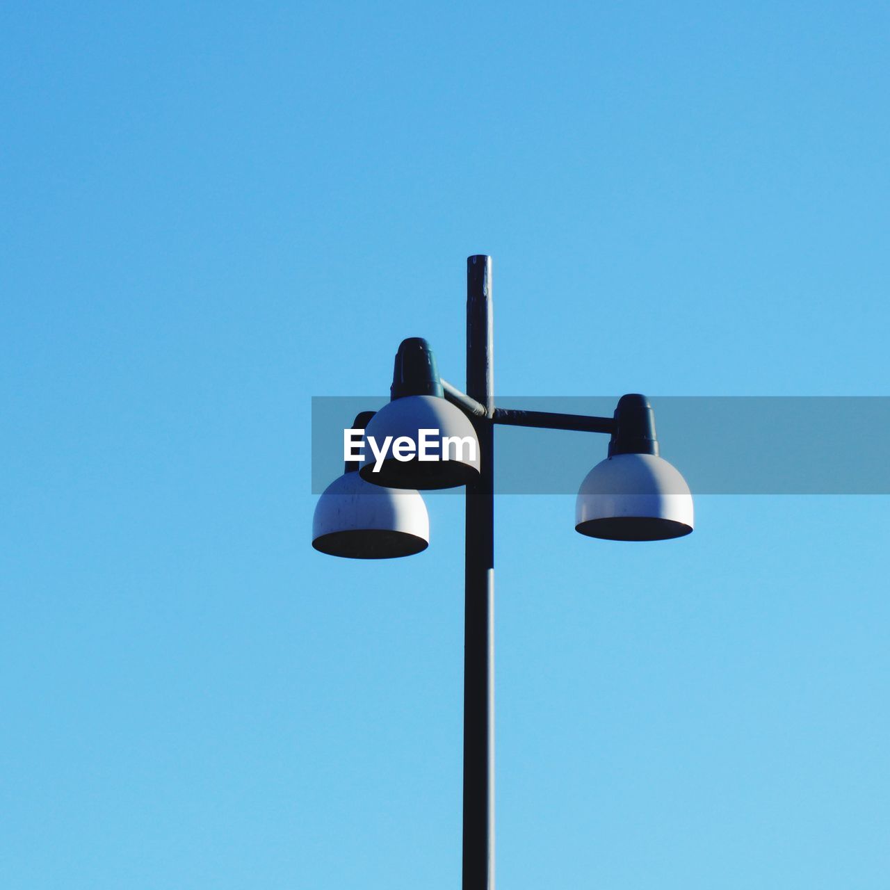 LOW ANGLE VIEW OF STREET LIGHTS AGAINST BLUE SKY