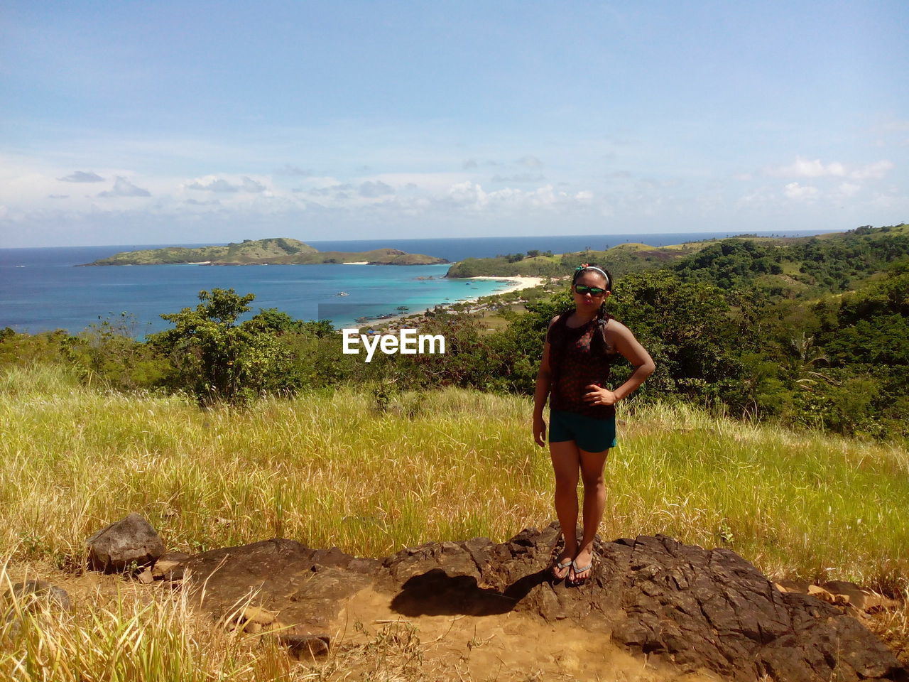 Portrait of woman standing on hill against sea at calaguas island