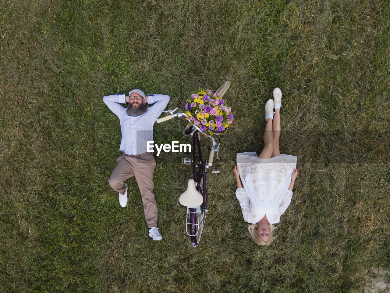 HIGH ANGLE VIEW OF FRIENDS LYING ON GRASS