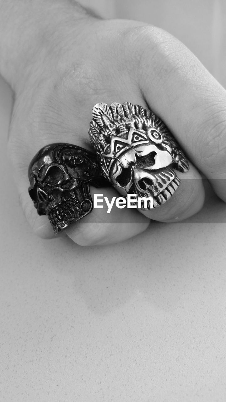 Cropped image of man with skull rings on table