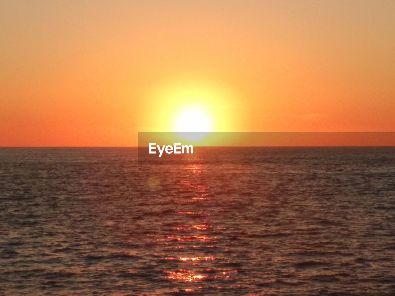 SCENIC VIEW OF SEA AGAINST CLEAR SKY AT SUNSET