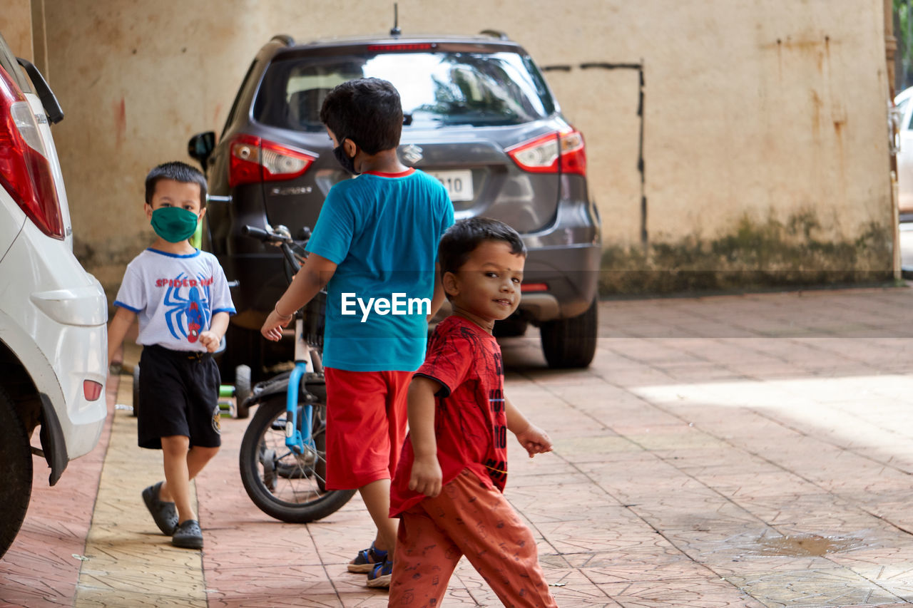 HIGH ANGLE VIEW OF CHILDREN IN CAR ON STREET