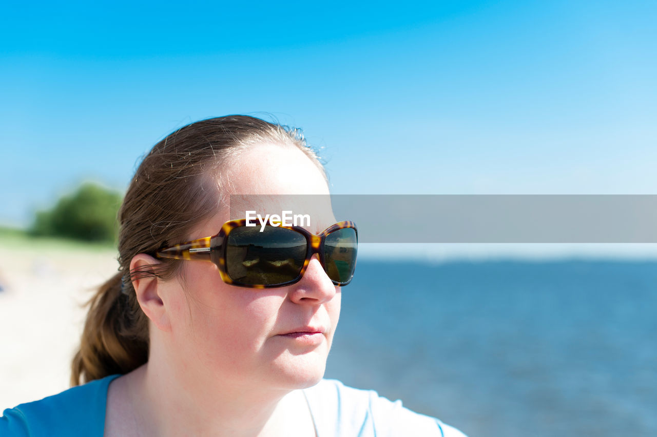 Close-up of woman wearing sunglasses at beach