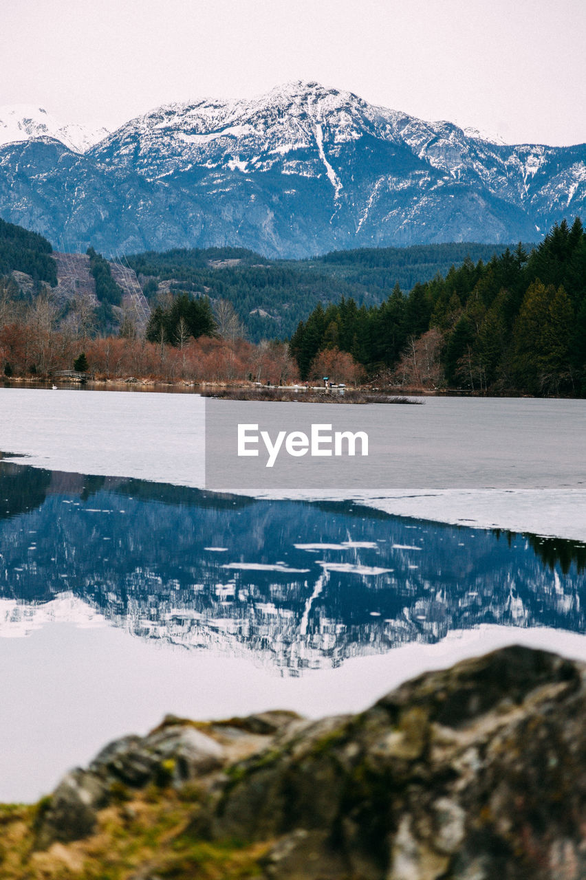 mountain, snow, scenics - nature, cold temperature, winter, environment, nature, water, beauty in nature, mountain range, landscape, lake, reflection, snowcapped mountain, tree, no people, wilderness, tranquil scene, sky, plant, land, tranquility, travel destinations, travel, day, coniferous tree, pinaceae, reservoir, pine tree, non-urban scene, outdoors, pine woodland, forest, tourism, ice, mountain peak