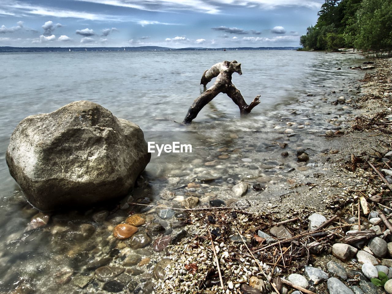 FULL LENGTH OF MAN ON ROCK AT SEA SHORE