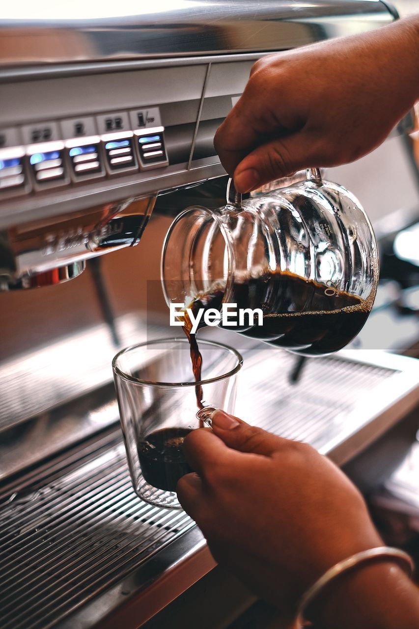 Cropped image of man pouring coffee in cup