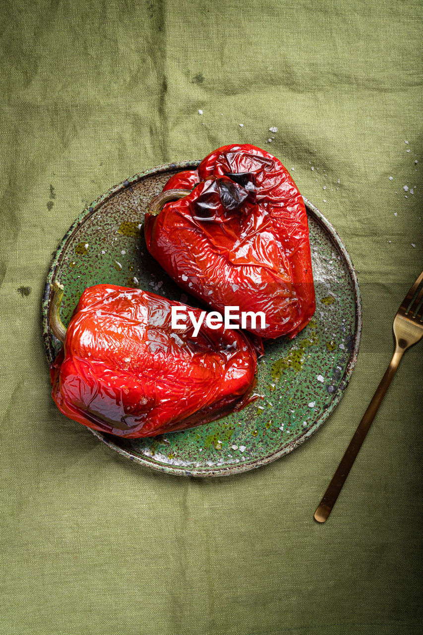 From above of appetizing roasted red pepper served on ceramic plate on green tablecloth