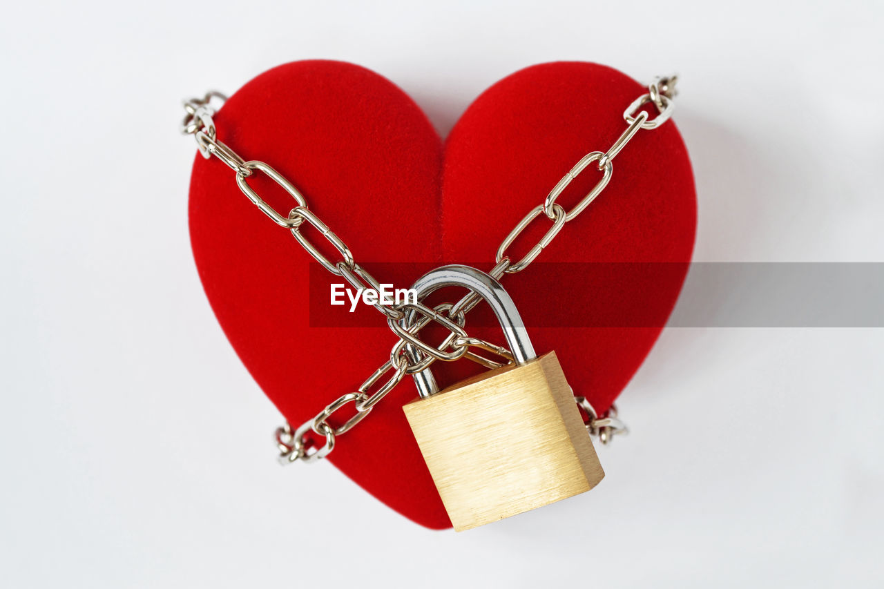 Heart shape locked with padlock against white background