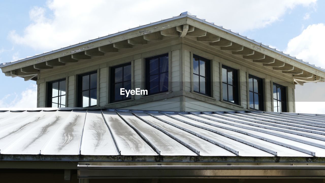 LOW ANGLE VIEW OF BUILDING AGAINST CLOUDS