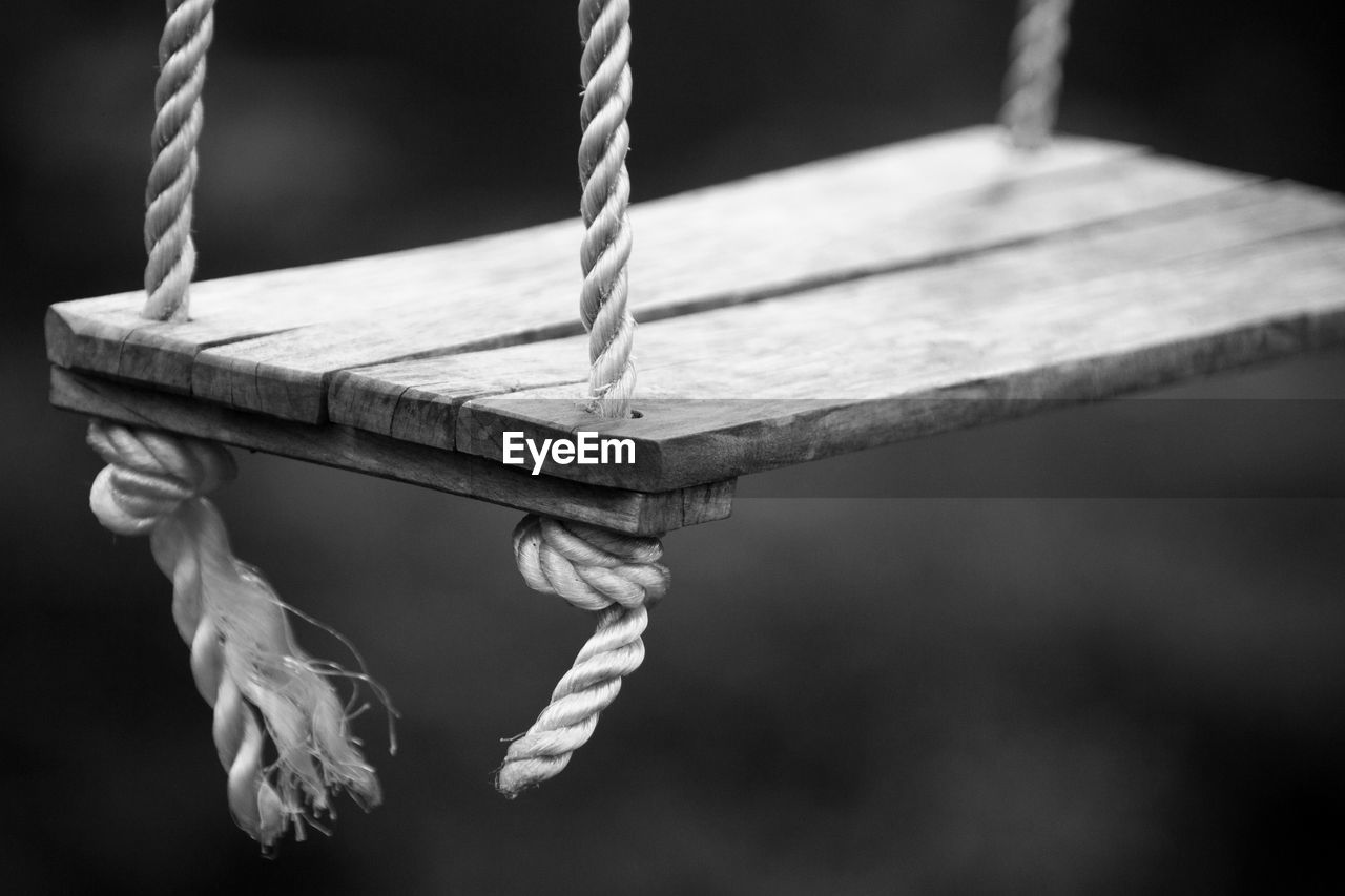 CLOSE-UP OF SWING TIED TO WOODEN POST