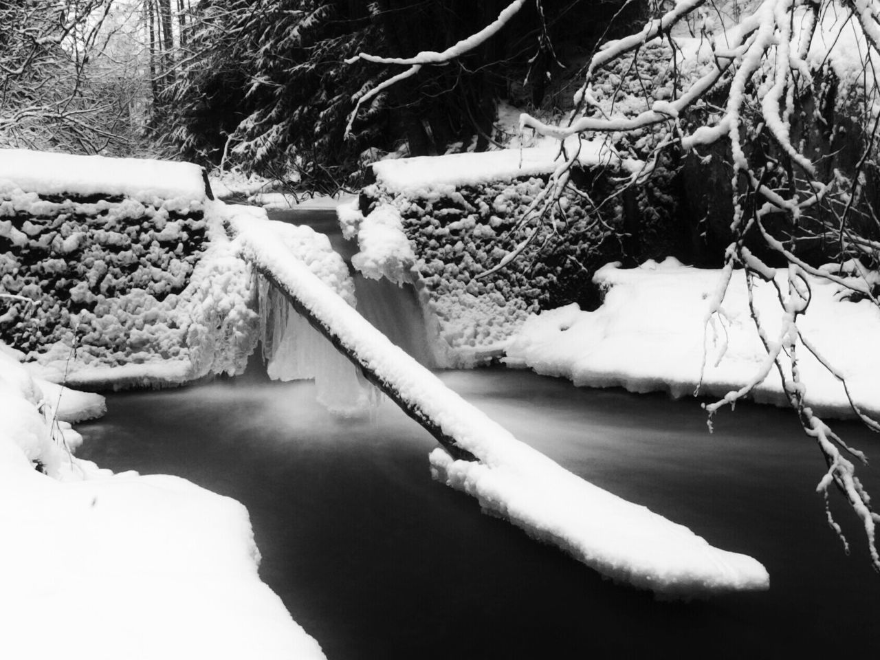 Broken snow covered sign board over frozen river