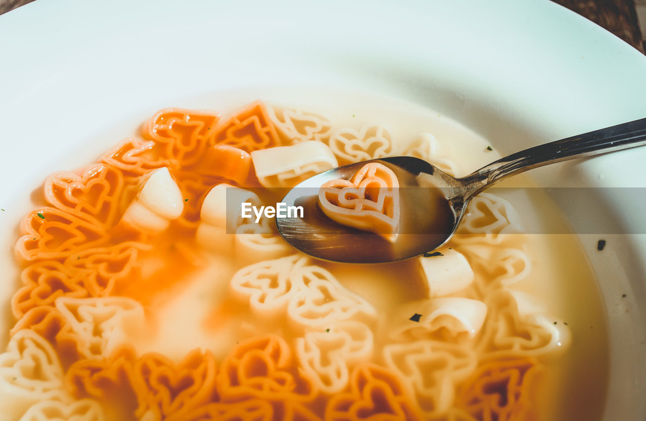 Close-up of heart shape pasta soup in plate