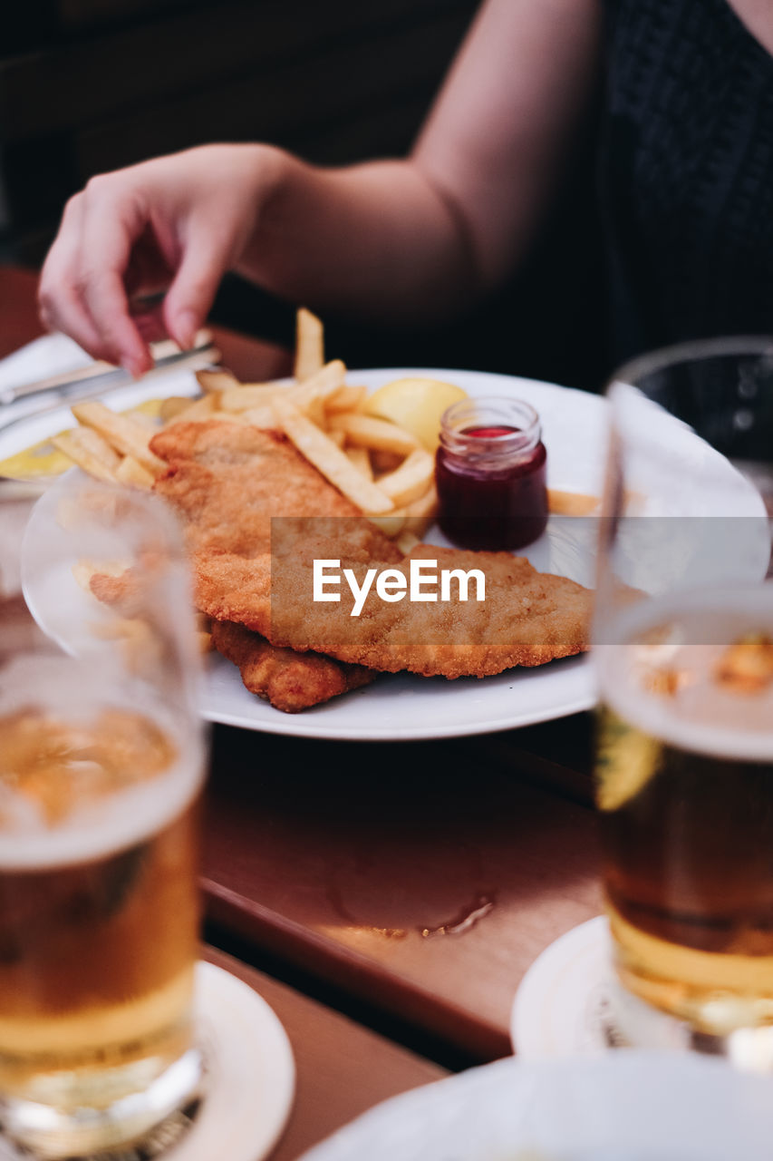 Midsection of woman eating food in restaurant