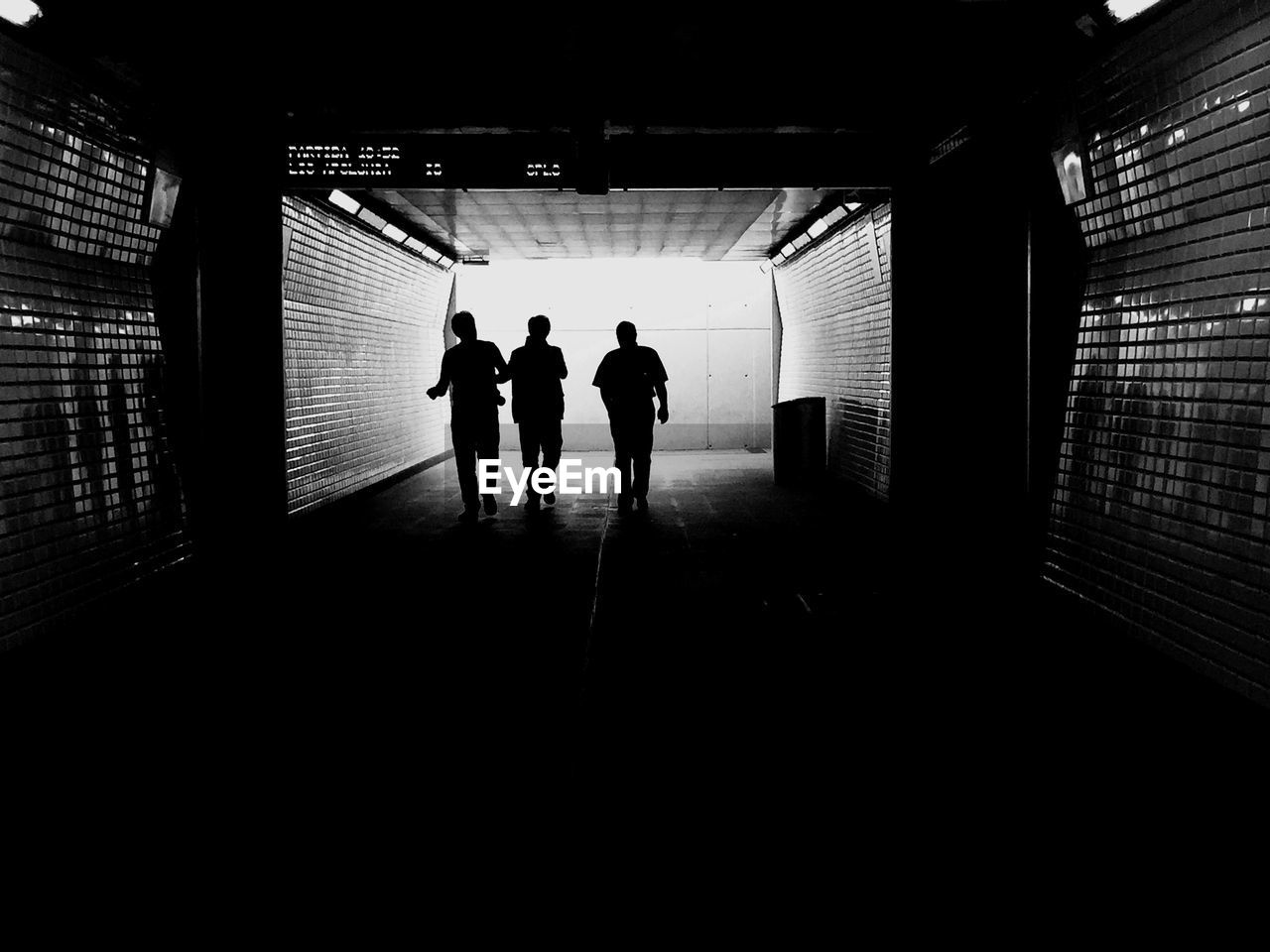 Silhouette people walking in building