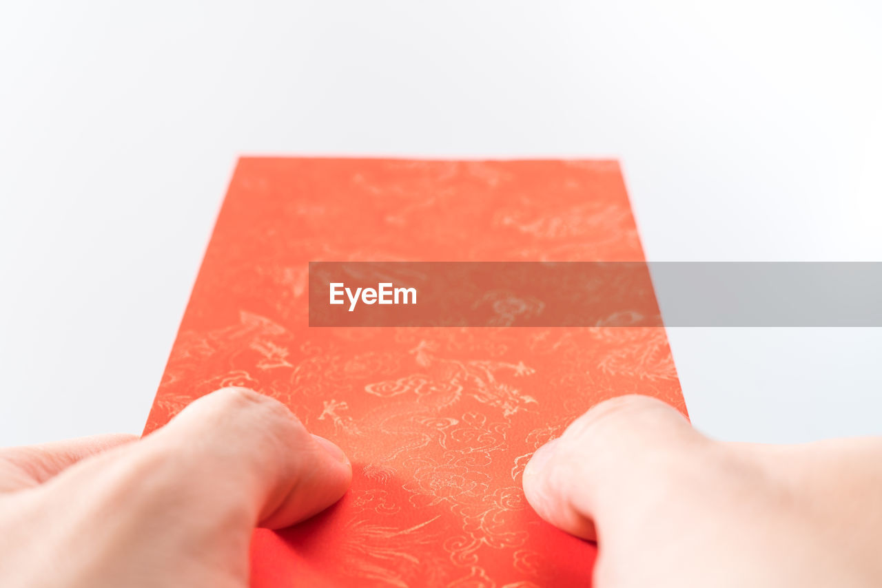 hand, red, holding, one person, close-up, studio shot, indoors, white background, adult, paper, copy space, text, finger, cut out