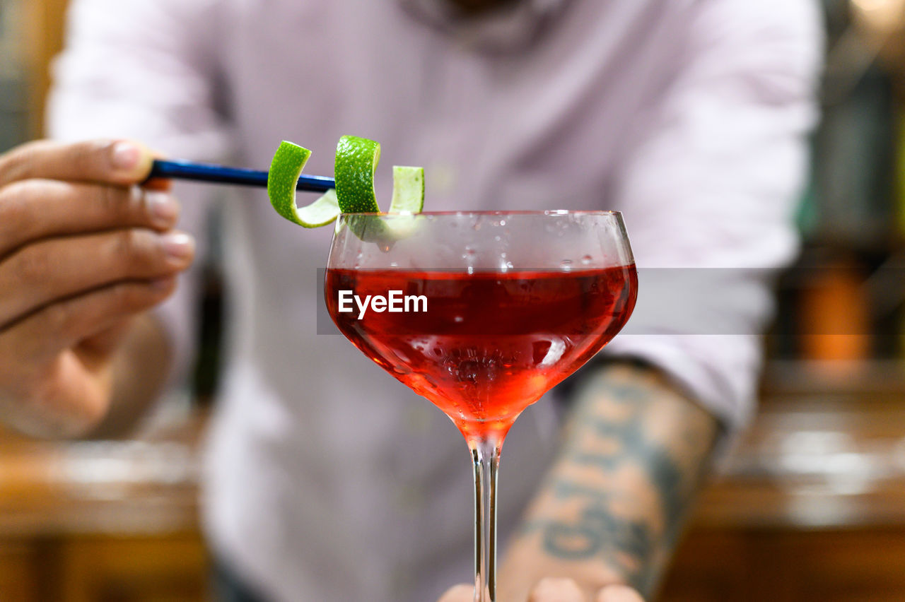 CLOSE-UP OF A HAND HOLDING WINEGLASS