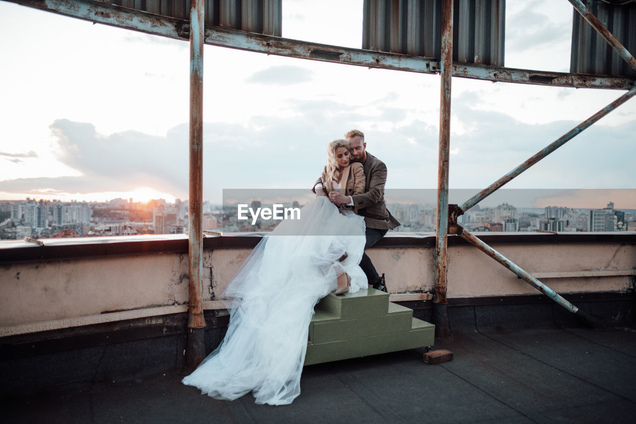 Full length of woman standing by window against sky