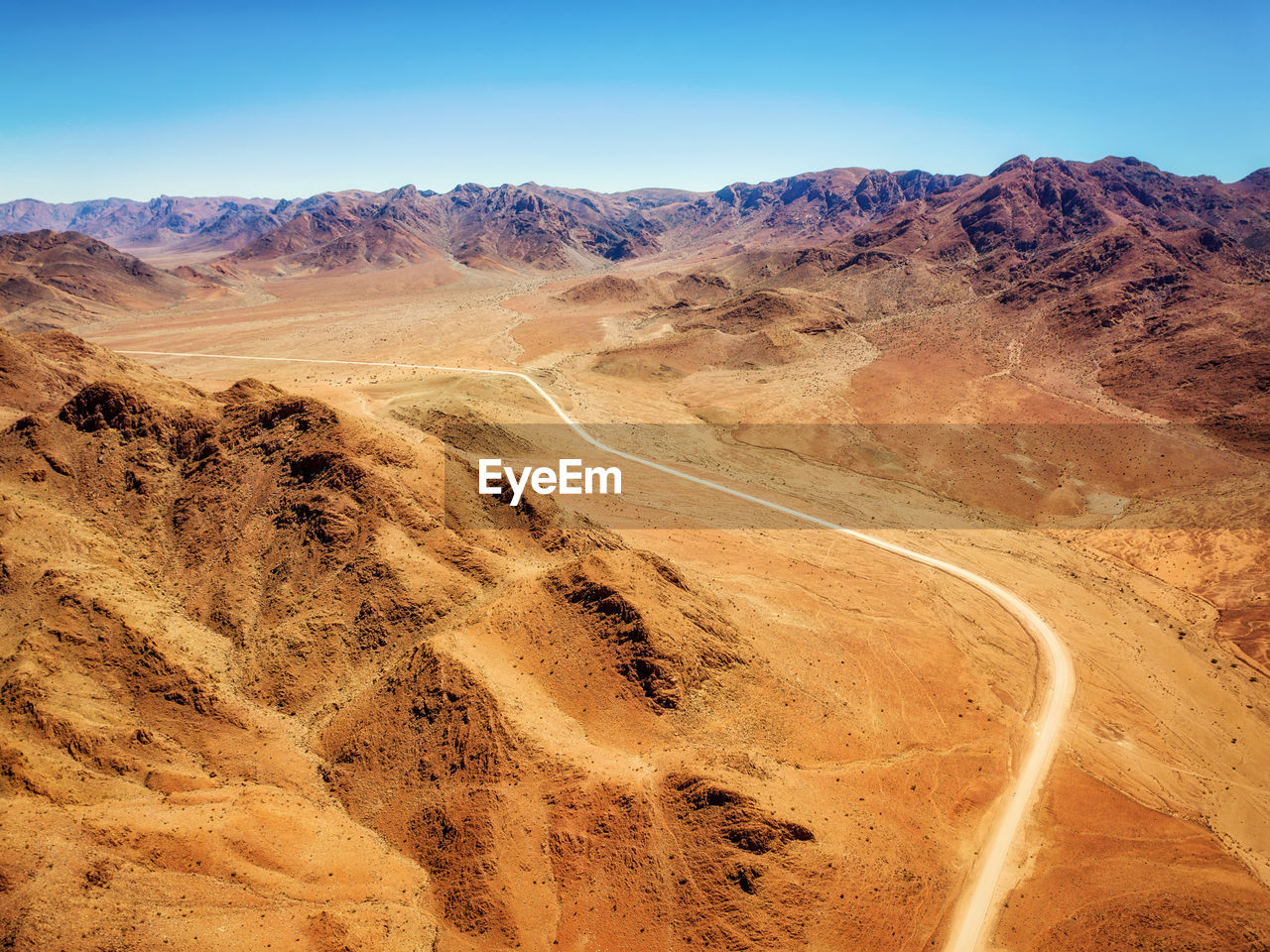 Scenic view of desert road against sky