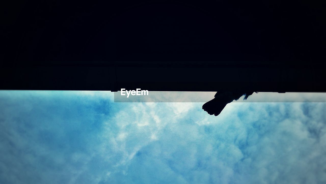 LOW ANGLE VIEW OF SILHOUETTE HANGING ON SKY