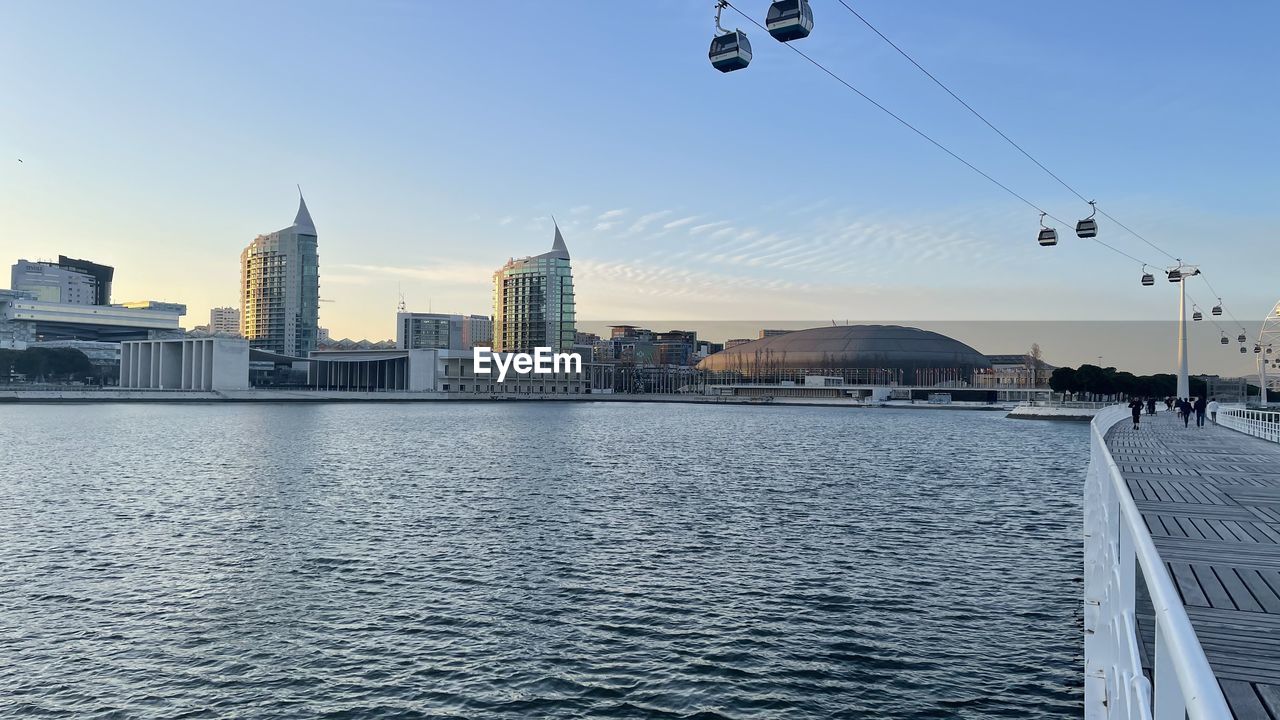 SEA BY BUILDINGS AGAINST SKY